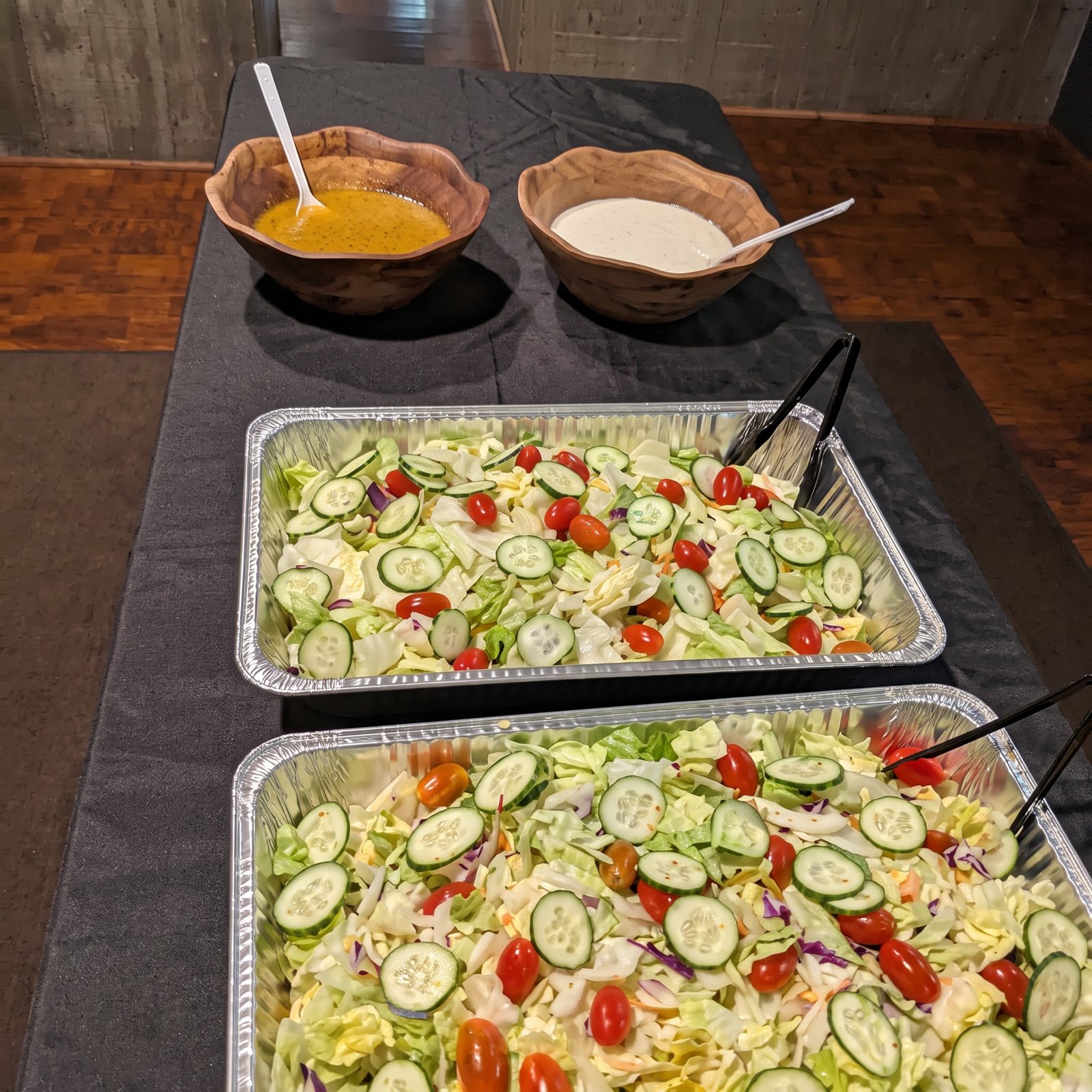 Garden salads with house dressings on a catering table