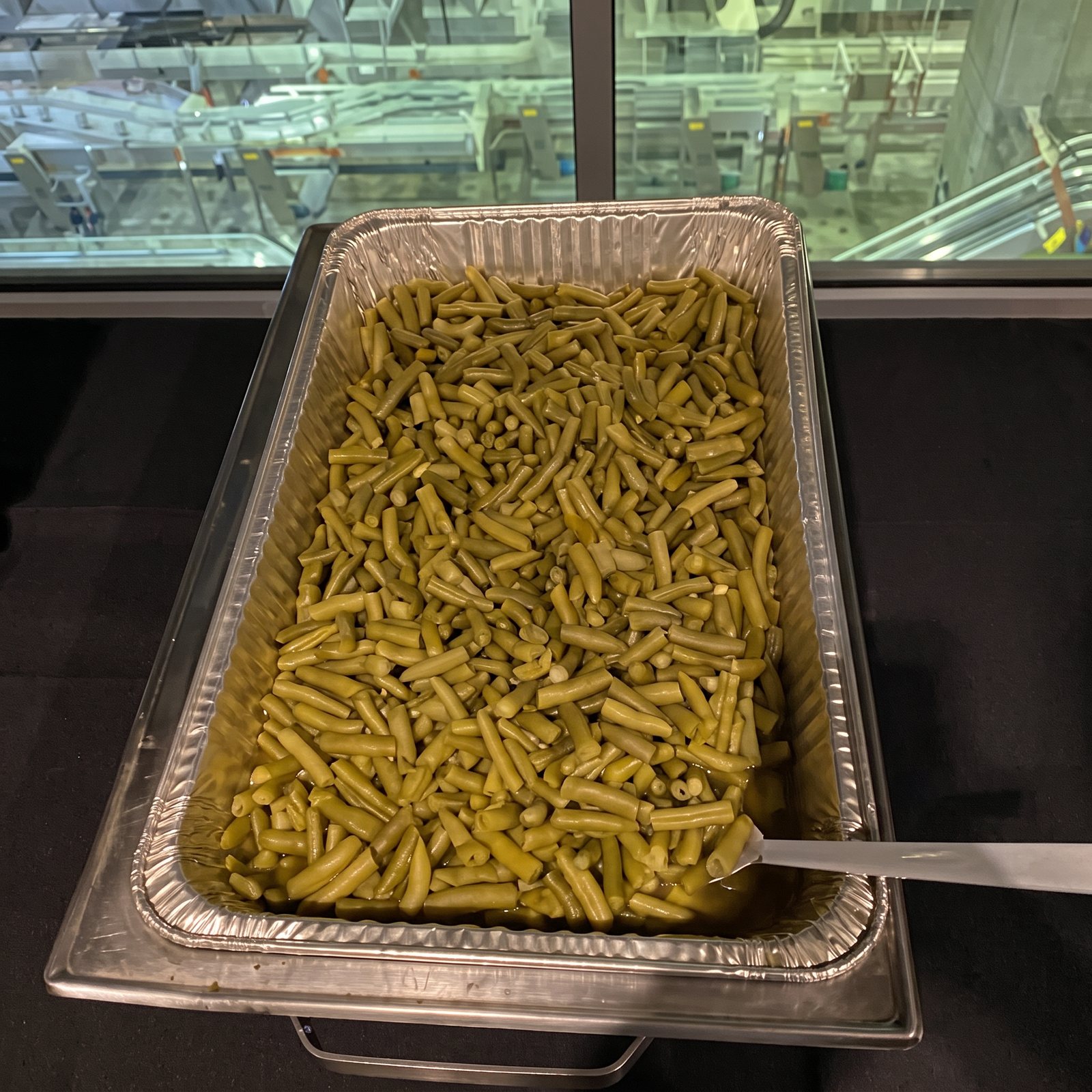 Chafing pan of seasoned green beans on a buffet